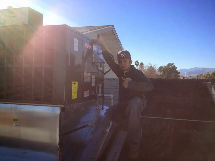 HVAC technician performing HVAC Inspection on a rooftop unit in Kenmore